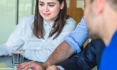 Jóvenes y mentores colaborando frente a un portátil en un entorno de innovación.