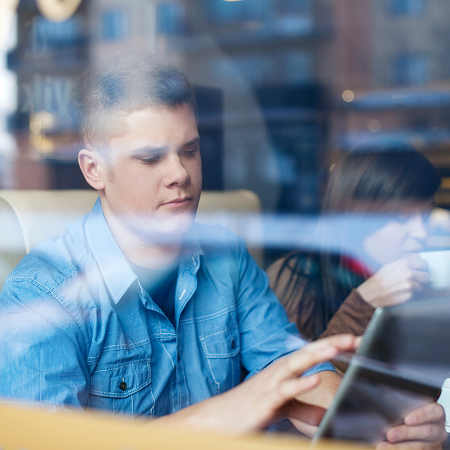 Adolescente utilizando una tablet en un espacio de trabajo colaborativo