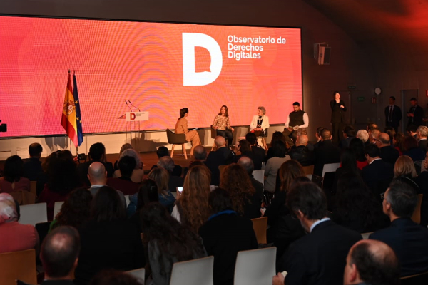 Auditorio con asistentes y ponentes durante un evento del Observatorio de Derechos Digitales, con pantalla principal en rojo.